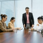 Professional team engaged in a meeting around a polished wooden table in a modern office.